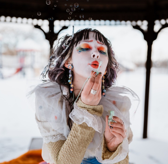 Children laughing at a clown with balloon animals